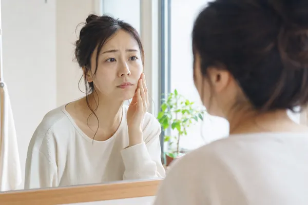 鏡で肌の調子をチェックする産後ママ